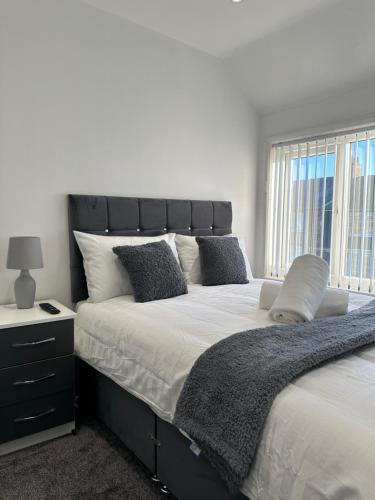 a bedroom with a large bed with a black headboard at Marvellous & Stylish Place in Middlesbrough