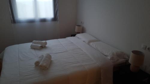een slaapkamer met een wit bed en handdoeken bij Apartamento Comares in Comares
