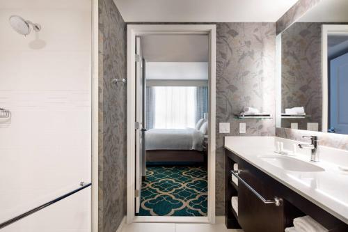 a bathroom with a sink and a mirror and a tub at Residence Inn by Marriott Los Angeles Pasadena/Old Town in Pasadena