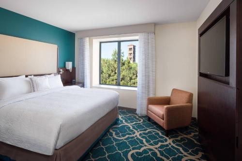 Residence Inn by Marriott Los Angeles Pasadena/Old Town في باسادينا: غرفه فندقيه بسرير وكرسي