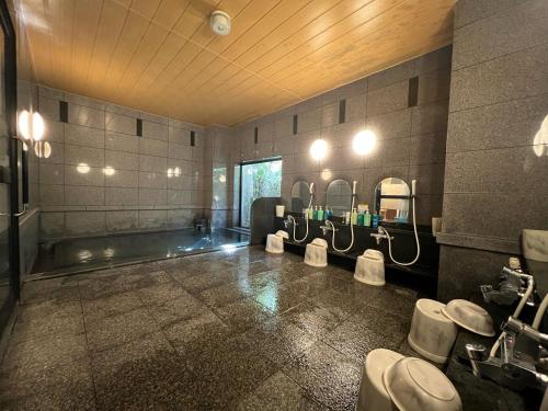弘前市にあるホテルルートイン弘前城東のバスルーム(洗面台3つ、鏡、トイレ付)