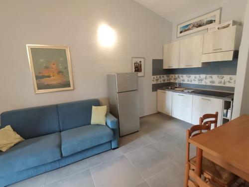 un soggiorno con divano blu e una cucina di Casa di Giò - Bilocale con giardino a Porto Pollo