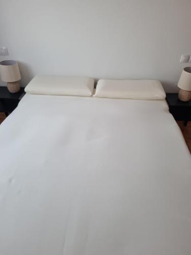 - un lit blanc avec 2 oreillers dans l'établissement Apartamento Comares, à Comares
