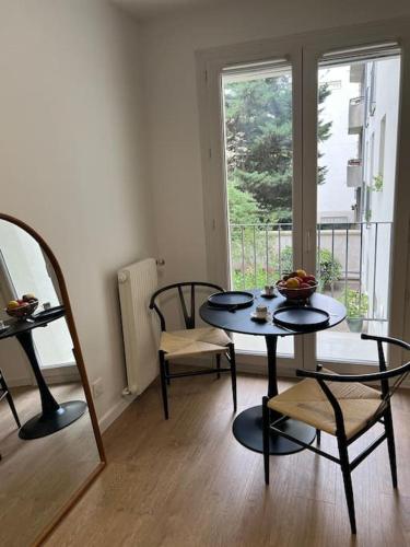 une pièce avec une table, des chaises et une fenêtre dans l'établissement Studio Chic & cosy au cœur de La Butte aux cailles, à Paris