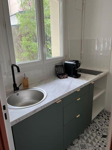 La salle de bains est pourvue d'un lavabo et d'une fenêtre. dans l'établissement Studio Chic & cosy au cœur de La Butte aux cailles, à Paris