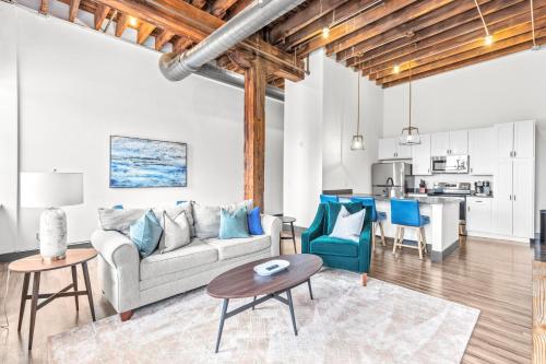 a living room with a couch and a table at Brick & Bed Riverfront Lofts, PC 104 in Saint Louis