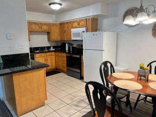 a kitchen with a table and a white refrigerator at Lovely 1bed,1bath condo with free parking in Fresno