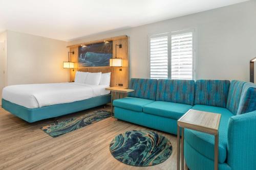 a hotel room with a bed and a couch at Best Western Plus Capitola By-the-Sea Inn & Suites in Capitola