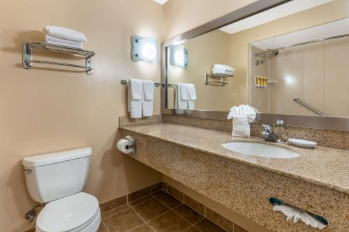 W łazience znajduje się umywalka, toaleta i lustro. w obiekcie Best Western Plus Capitola By-the-Sea Inn & Suites w mieście Capitola