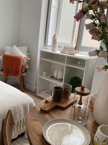 une table dans une pièce avec une fenêtre et une table avec une assiette dans l'établissement Appartement Plein Centre, à Lyon