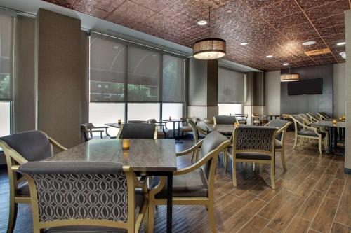 a dining room with tables and chairs and windows at Drury Plaza Hotel San Antonio Riverwalk in San Antonio