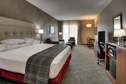 a hotel room with a bed and a living room at Drury Plaza Hotel San Antonio Riverwalk in San Antonio