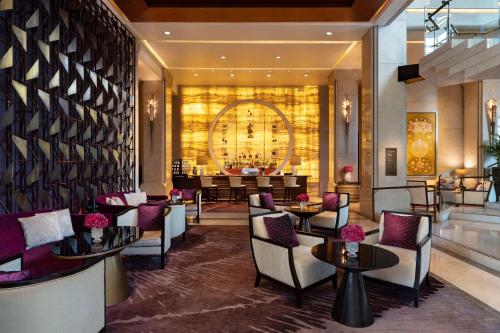 a lobby with chairs and tables and a bar at Siam Kempinski Hotel Bangkok - SHA Extra Plus Certified in Bangkok