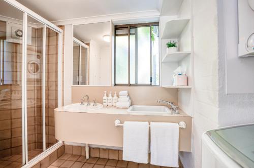 uma casa de banho com um lavatório e um espelho em Ocean Breeze Resort em Noosa Heads