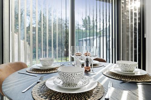 a table with plates and glasses on a table with a window at Windsor House by Andrew Hart Property in Stourbridge