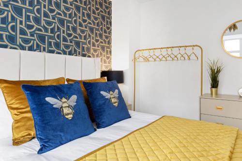 a bedroom with a bed with blue and gold pillows at Windsor House by Andrew Hart Property in Stourbridge