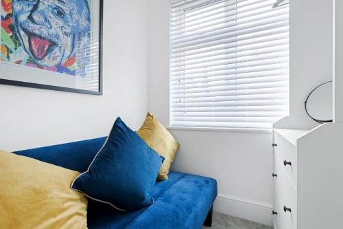 a blue couch in a white room with a window at Windsor House by Andrew Hart Property in Stourbridge