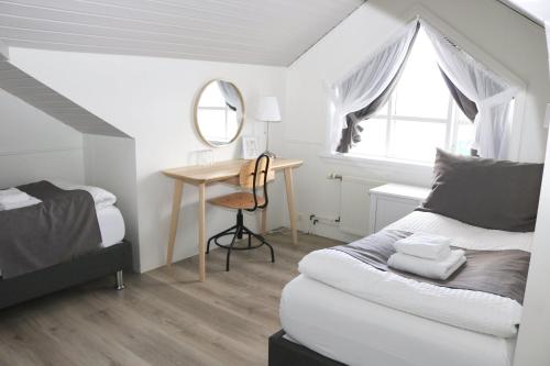 a bedroom with a bed and a desk with a mirror at Miðhraun - Lava resort in Midhraun