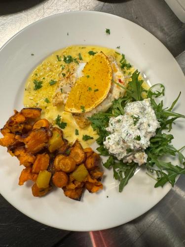 a white plate of food with an egg and vegetables at Miðhraun - Lava resort in Midhraun