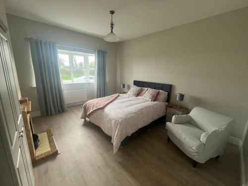 a bedroom with a bed and a couch and a window at House in the Burren Clare in Droíchead an Chláir