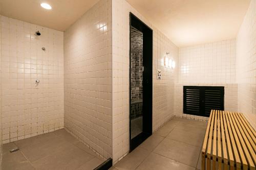 kabina prysznicowa z białymi kafelkami i czarnymi drzwiami w obiekcie Novo e Rústico Studio no Centro/Sauna - RJ/ w mieście Rio de Janeiro