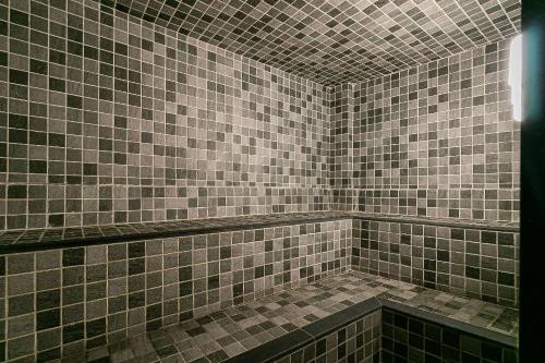 baño con paredes de azulejos marrones y avisor en Novo e Rústico Studio no Centro/Sauna - RJ/ en Río de Janeiro