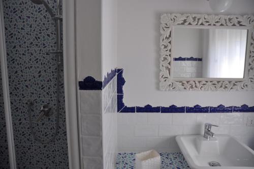 uma casa de banho com um lavatório, um espelho e um chuveiro em Le stanze di Rebecca em Tor Vergata