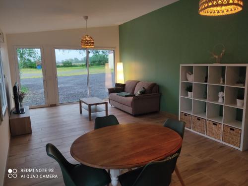 un salon avec une table et un canapé dans l'établissement Gîtes des Colombières Piscine & Spa, à Saint-Maixent-sur-Vie