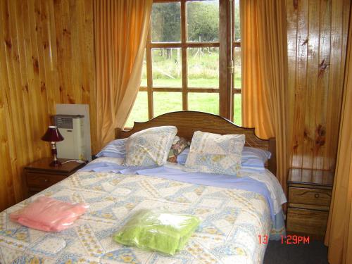 een slaapkamer met een bed met twee zakken erop bij Hosteria Catalina sm in Hornopiren
