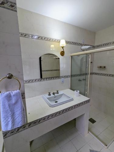 a bathroom with a sink and a shower at Casa Central Hospedagem in Miguel Pereira
