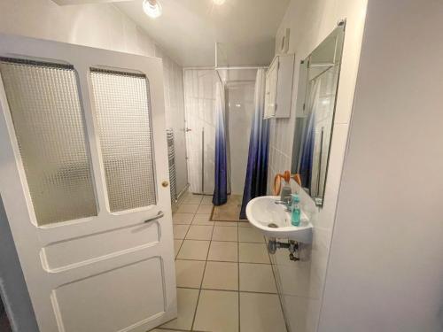 een witte badkamer met een wastafel en een spiegel bij Gite Le Lattier in Lussac-les-Églises