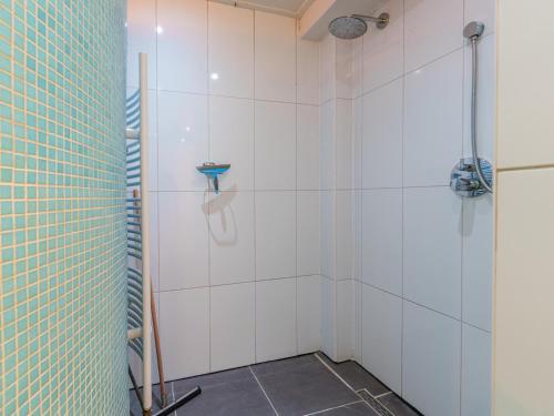 a bathroom with a shower with white tiled walls at Het Grootenhuis in Olst