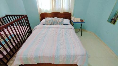 a bedroom with a bed with a striped comforter at Casa de Campo, en David Chiriquí, Cerca de Playa y Montañas in David