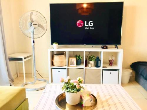a living room with a tv and a table with a fan at Madinaty Luxury Apartments New cairo in Madinaty