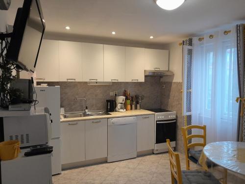 a kitchen with white cabinets and a sink and a table at Apartments with parking space Postira, Brac - 2911 in Postira