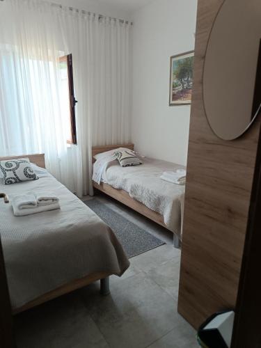 a bedroom with two beds and a mirror at Apartments by the sea Medveja, Opatija - 7722 in Lovran