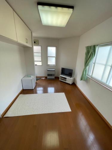 a living room with a white rug on a wooden floor at トリトン茶屋町#101#102 in Aomori