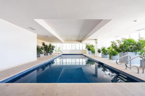 an indoor pool with plants in a building at Isolda Suites Vistas del Bosque in Mexico City