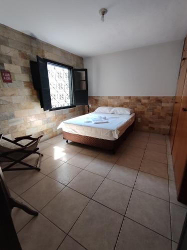 un dormitorio con una cama y una ventana en Cantinho do Aconchego, en Belo Horizonte