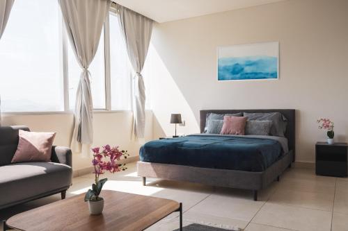 a bedroom with a bed and a couch at Isolda Suites Vistas del Bosque in Mexico City
