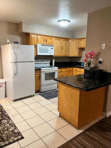 a kitchen with a white refrigerator and wooden cabinets at Quiet 1bed,1bath condo with free parking in Fresno