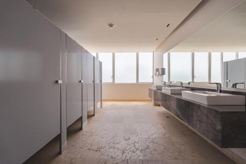 a bathroom with three sinks and a row of mirrors at Isolda Suites Vistas del Bosque in Mexico City