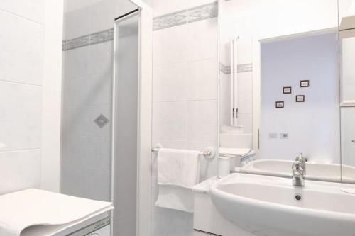 a white bathroom with a sink and a shower at Villini Al Vittoriale in Gardone Riviera
