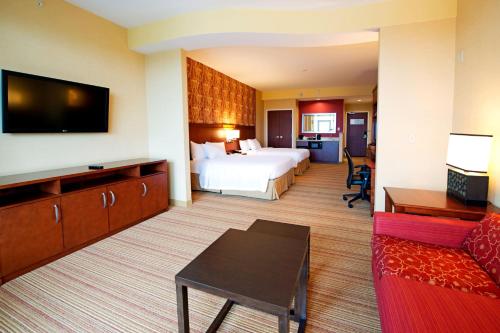 a hotel room with a bed and a tv at Courtyard by Marriott Ottawa East in Ottawa
