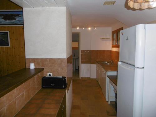 une cuisine avec un réfrigérateur blanc et un évier dans l'établissement Maison familiale avec jardin clos, proche des activités et loisirs, internet inclus - FR-1-410-129, à Mareil-sur-Loir