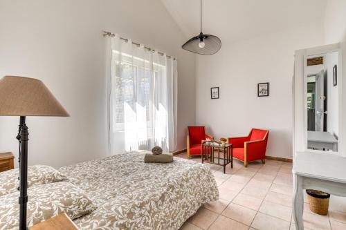 - une chambre avec un lit et deux chaises rouges dans l'établissement La Vintage, Maison 150 m2 au cœur de Montpellier, à Montpellier