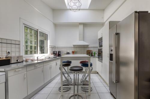 une cuisine avec des armoires blanches et des appareils en acier inoxydable dans l'établissement La Vintage, Maison 150 m2 au cœur de Montpellier, à Montpellier