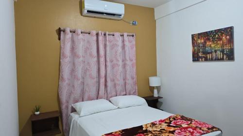 - une chambre avec un lit et un rideau rose dans l'établissement Cozy private APT in La Ceiba, à La Ceiba