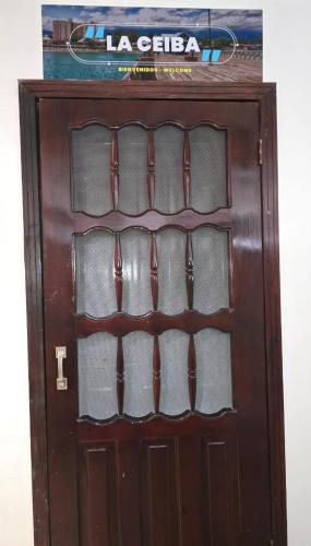 a brown wooden door with a sign on top at Cozy private APT in La Ceiba in La Ceiba