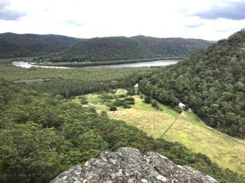 a view of a hill with a river and a field at Nature Retreat & Artists Studio 90mins from Sydney in Spencer